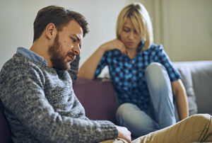Married couple reflect while sitting on couch during relationship therapy