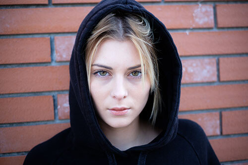 Woman in hoodie struggles with her additive personality