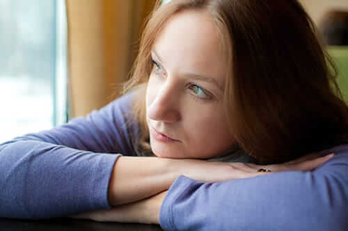 Woman rests her head on her hands as she images an Idaho rehab center