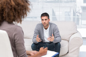 Man sits on couch and talks to therapist abou this opiate addiction