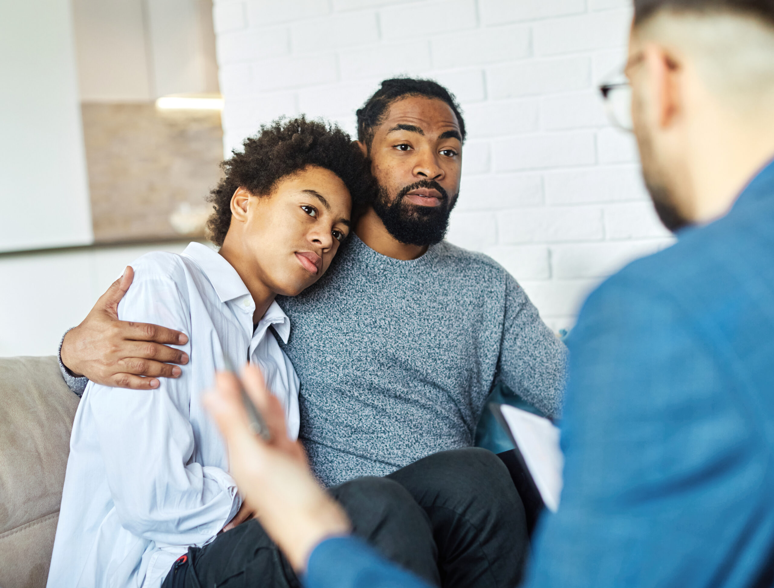 Man hugs his son during mental health treatment