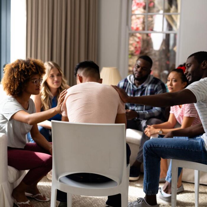 People comfort a peer during drug addiction treatment
