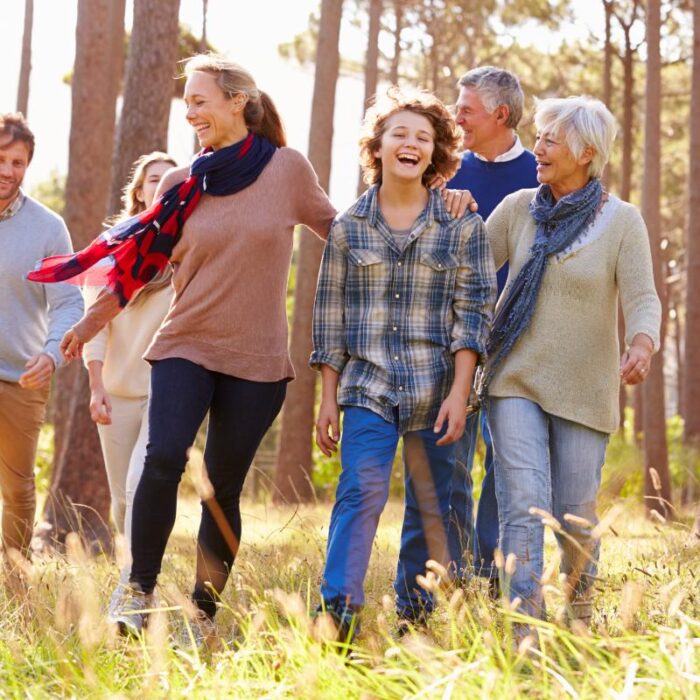 Family laughs and smiles while walking in the woods
