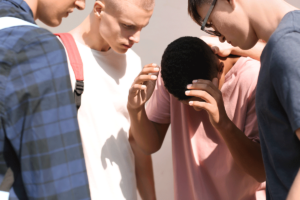 Three teens surrounding another teen representing peer pressure