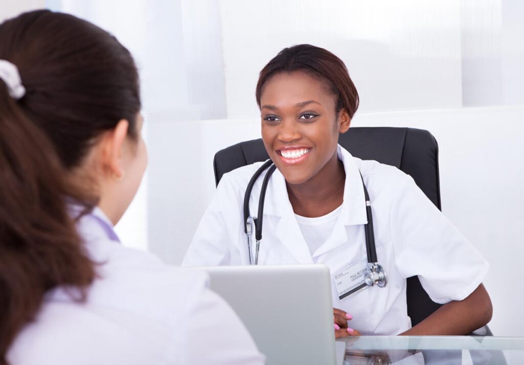 Nurse smiling at a patient at a laptop