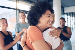 Two women embracing after successful addiction recovery