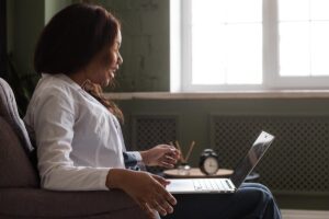Woman looking at her laptop for a telehealth addiction recovery appointment