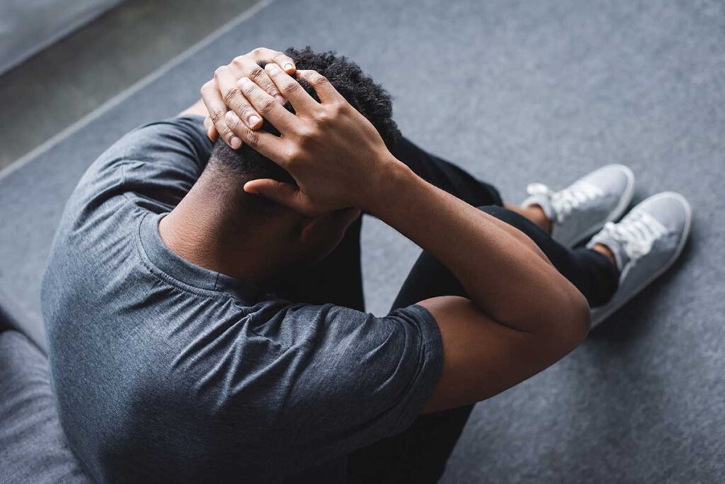 Man holds his head in hands as he learns what a panic attack feels like