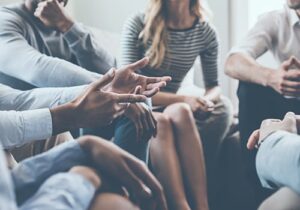People talk in group therapy while in an adult rehab program