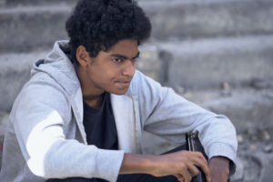 Teen sits on stairs drinking, wondering if alcohol is a depressant