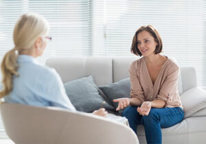Woman sits on couch and talks to therapist in prescription drug abuse treatment in Boise, Idaho