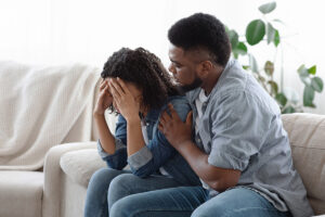 Two people wondering, "What causes PTSD in adults?"