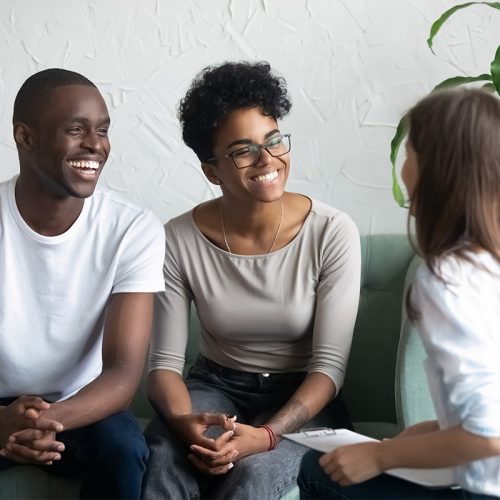 Couple smiles as they talk to therapist in addiction treatment program